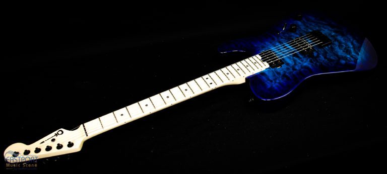 A blue electric guitar sitting on top of a black table.