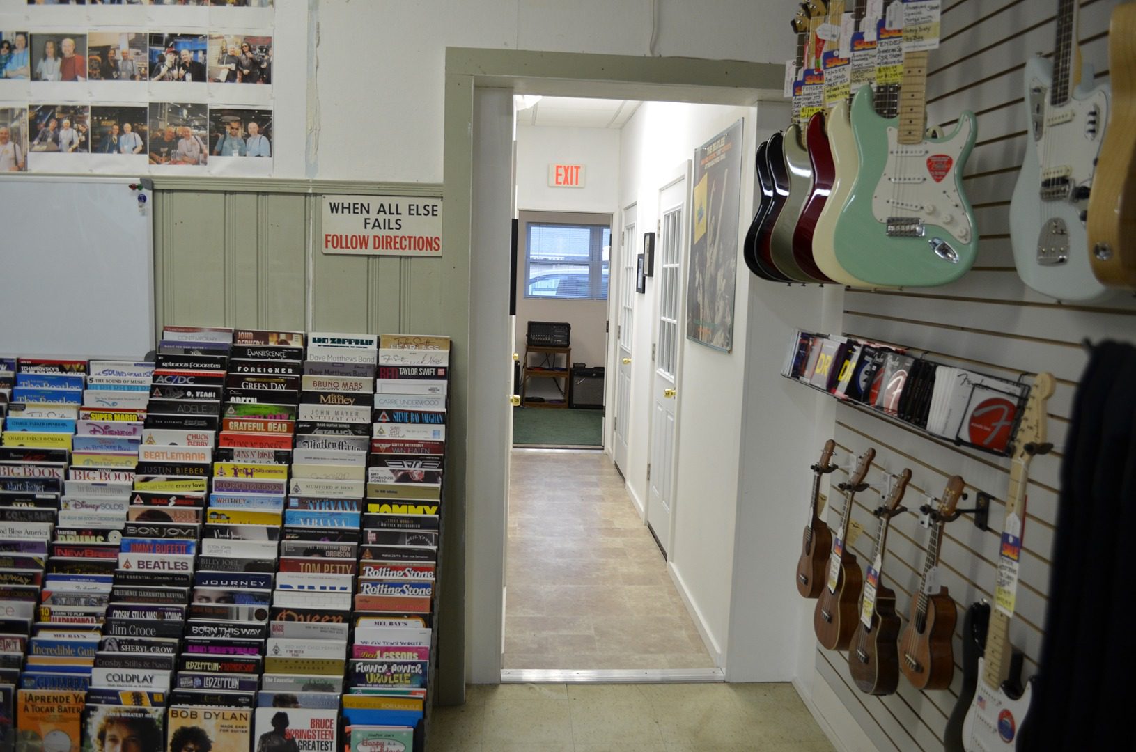 A room filled with lots of books and guitars.