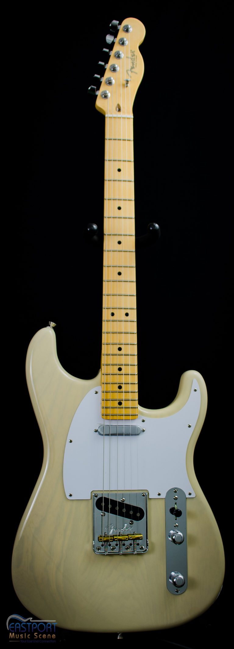 A white electric guitar with black and yellow neck