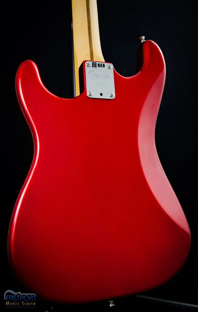 A red guitar with a yellow pick holder.