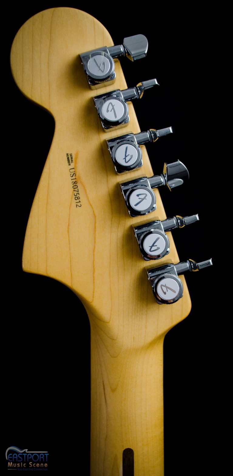 A guitar with four different knobs on it.