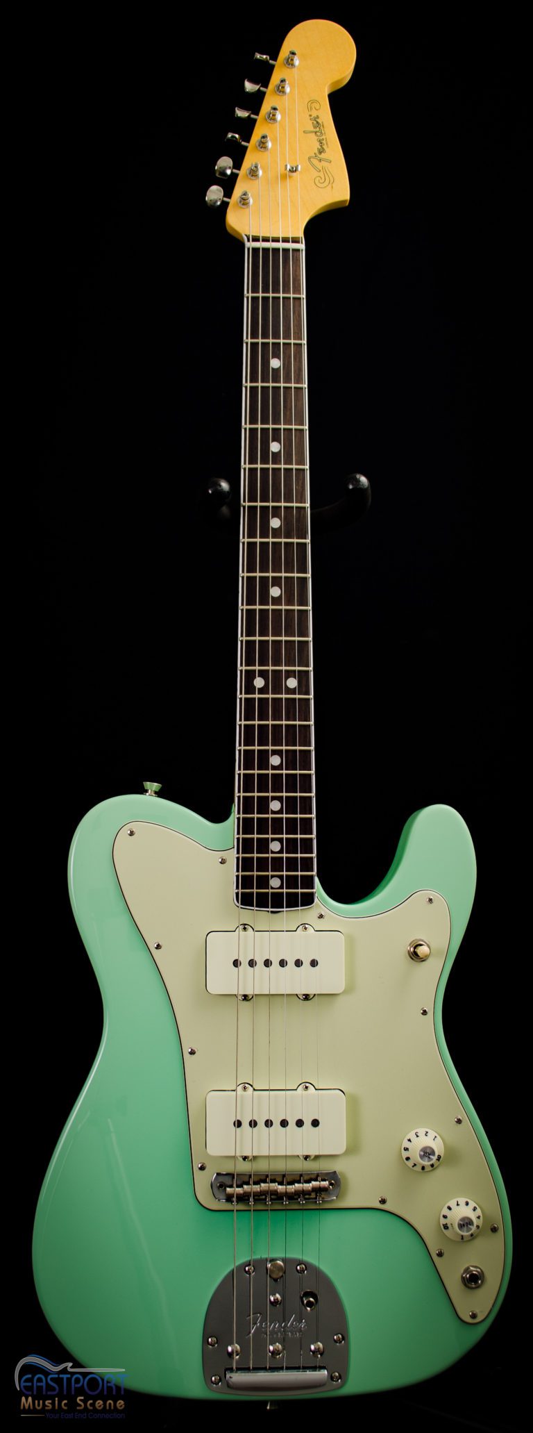 A green electric guitar with the strings missing.