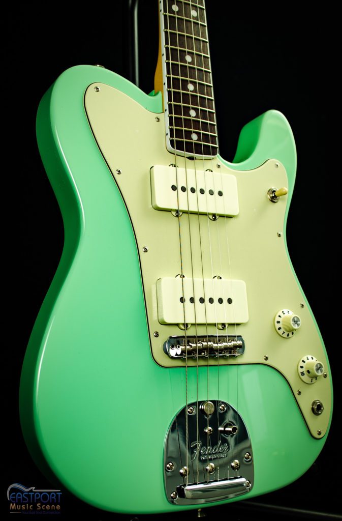 A green electric guitar with the strings missing.