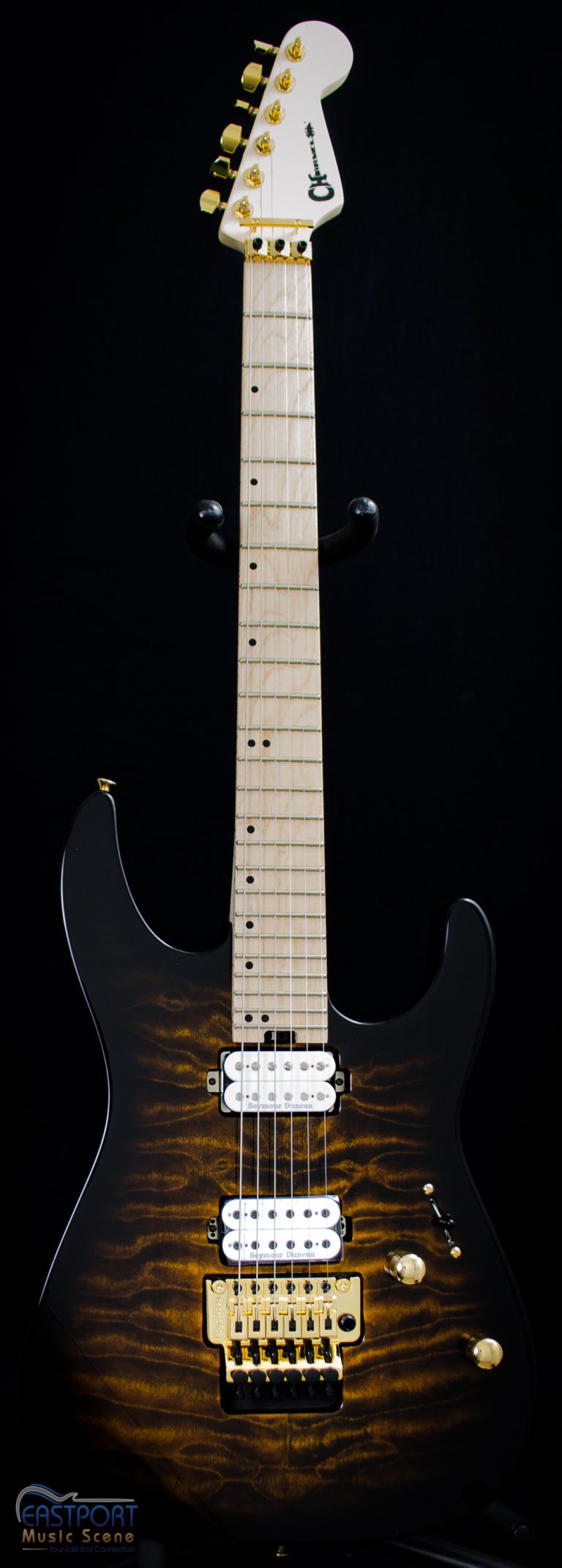 A black and brown electric guitar with the strings missing.