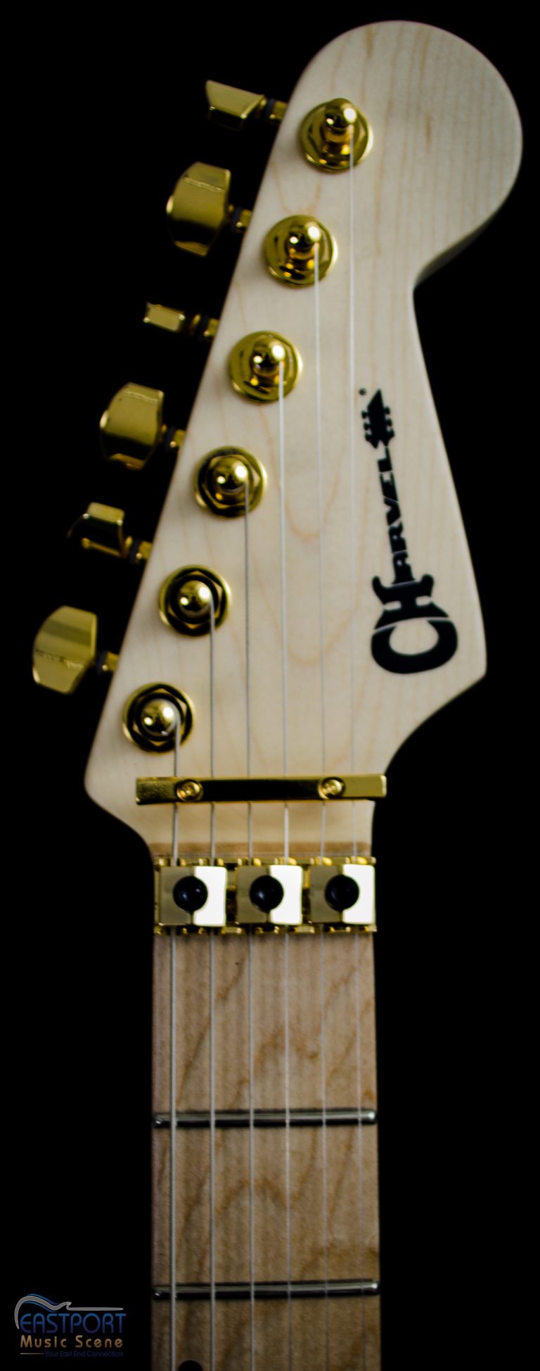 A close up of the neck and strings on an electric guitar.