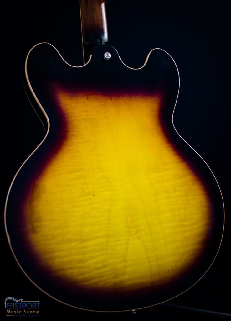 A guitar that is sitting in the dark.