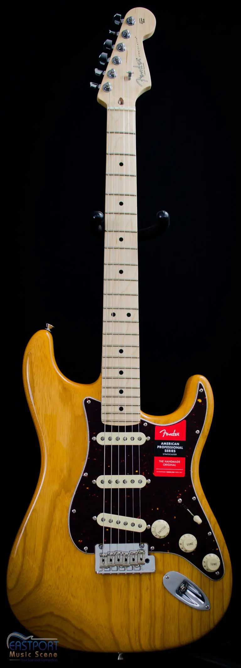A yellow electric guitar with black neck and head.