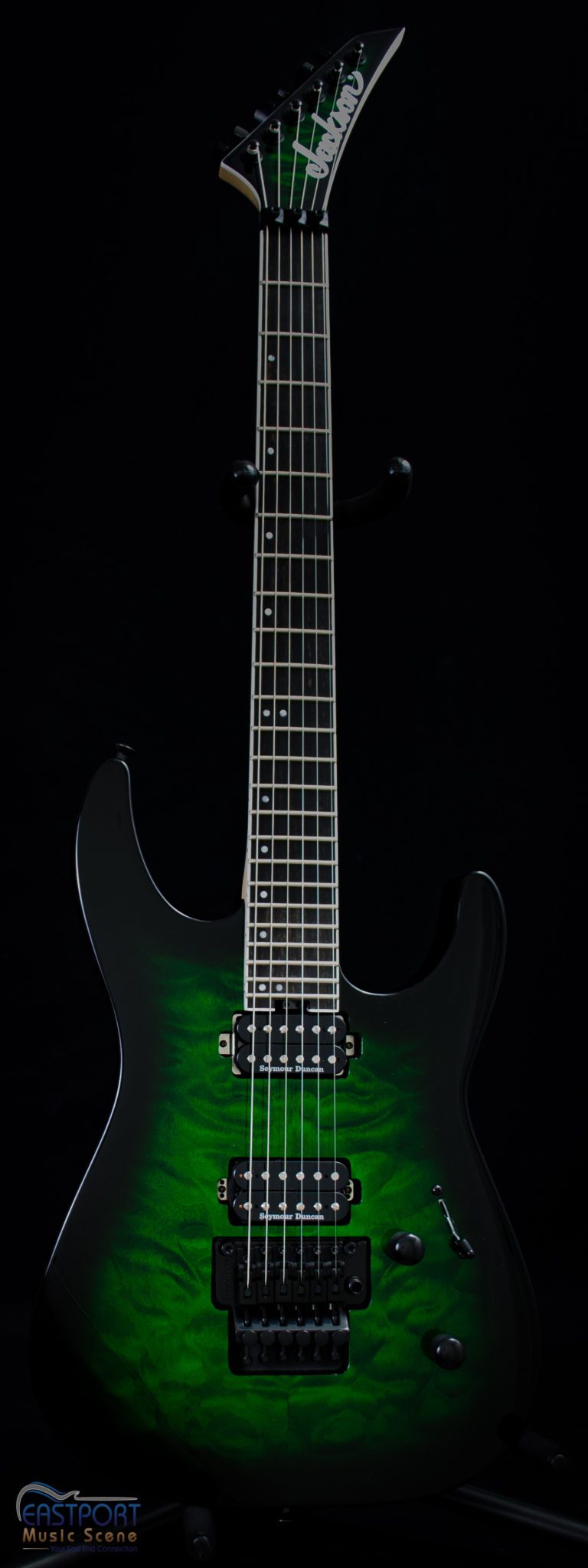 A green electric guitar with black body and neck.