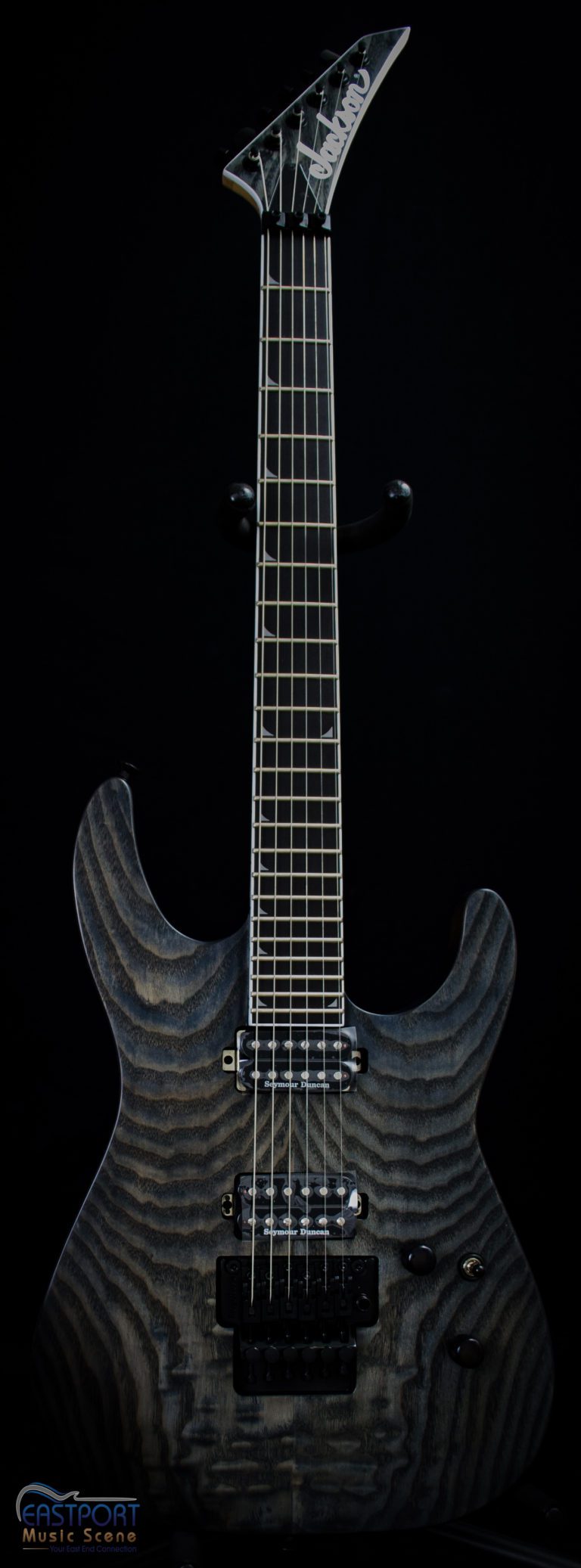 A black electric guitar with a wooden design on it.