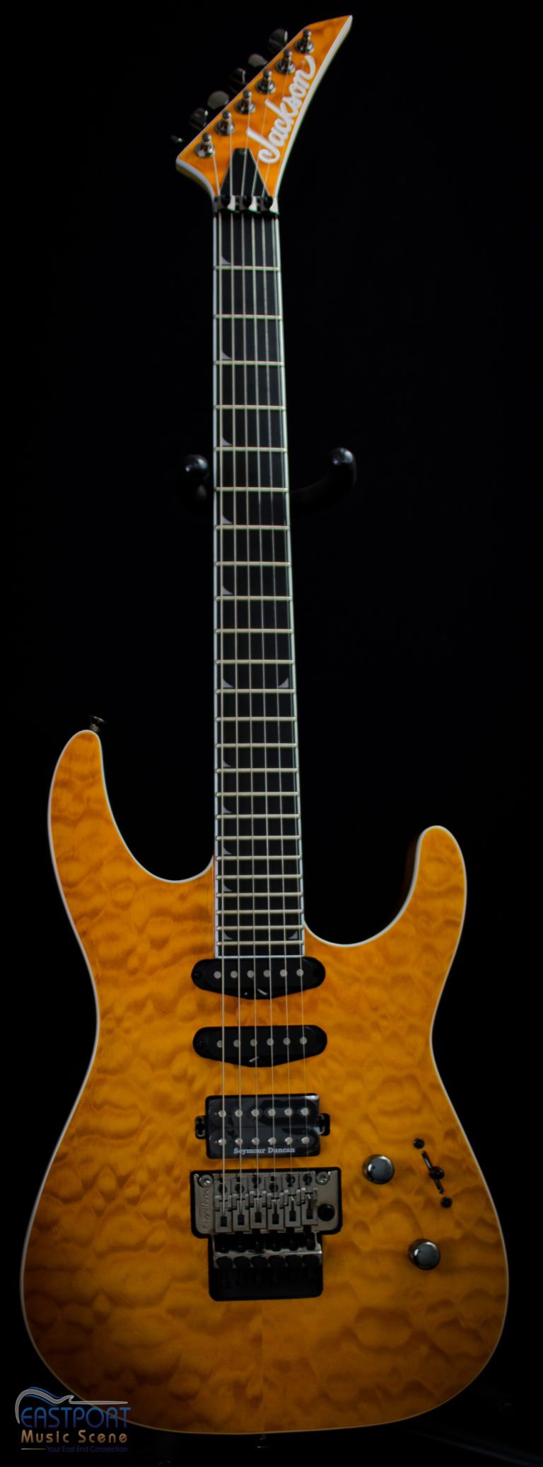 A guitar with an orange body and black neck.