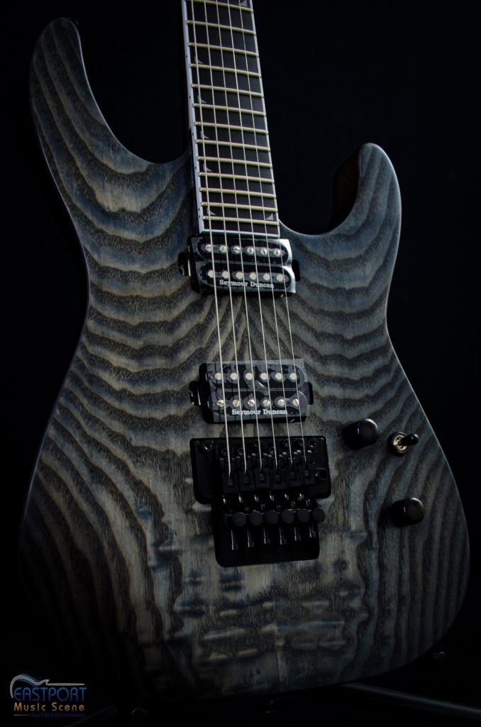 A black electric guitar with a wooden finish.