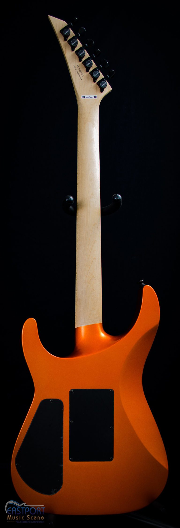 A guitar with an orange body and white neck.