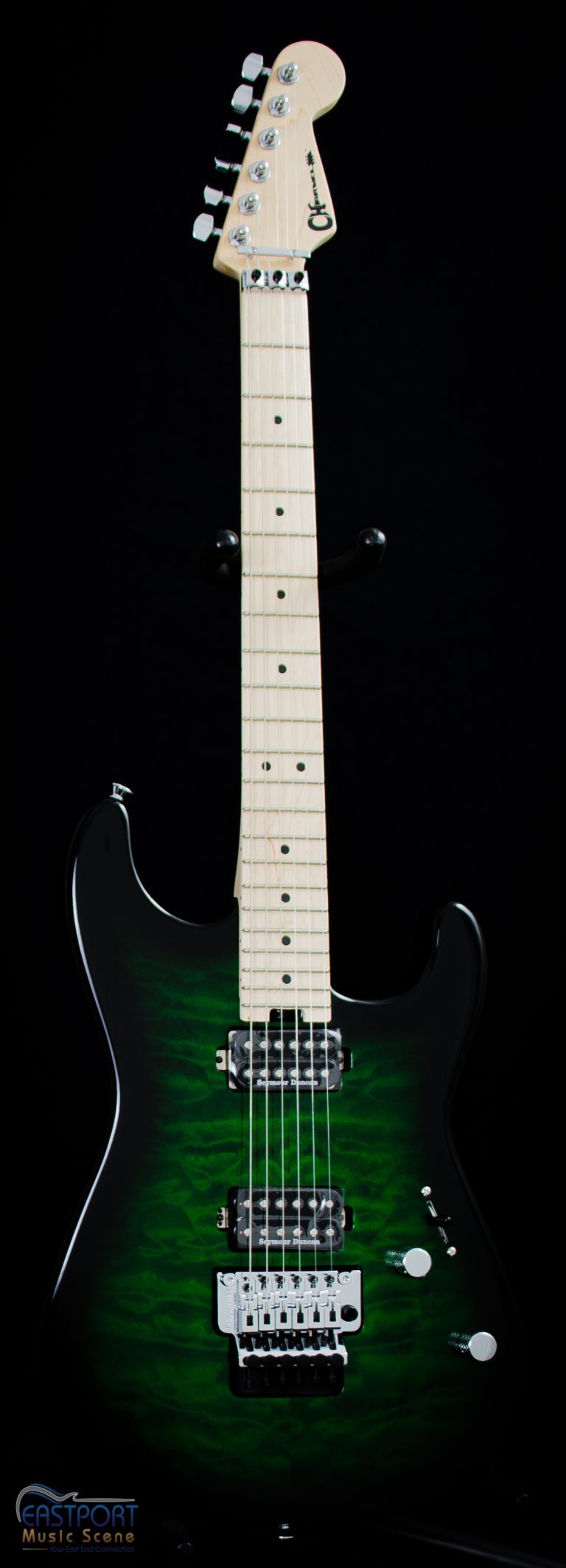 A green and black guitar is in front of a black background.