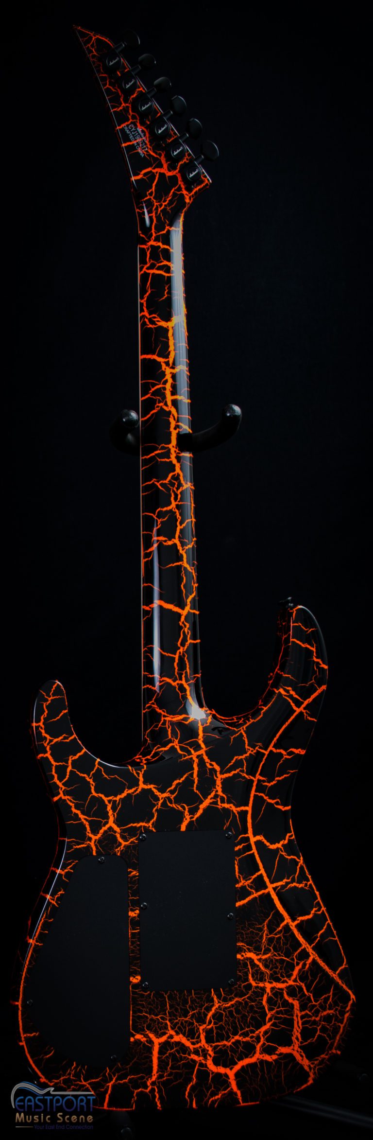 A guitar with orange and black paint on it.