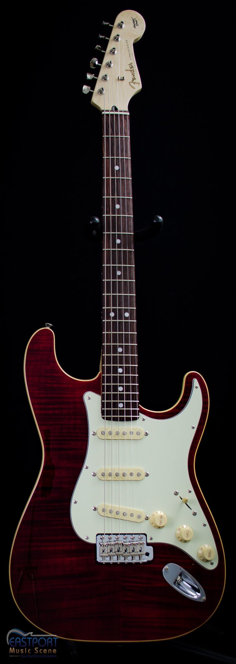 A red electric guitar with the strings missing.