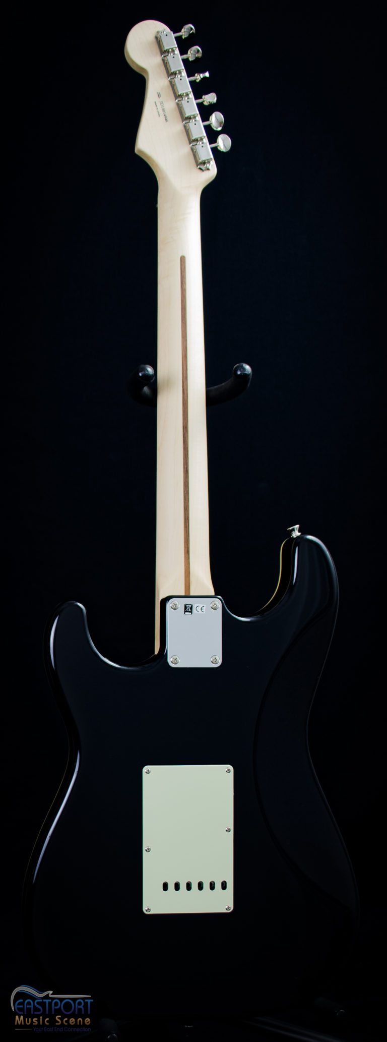 A black electric guitar with a white pick guard.
