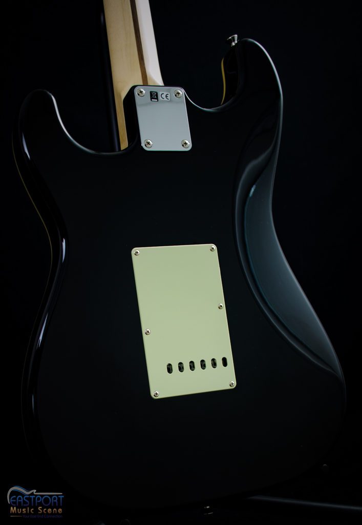 A black electric guitar with a white label.