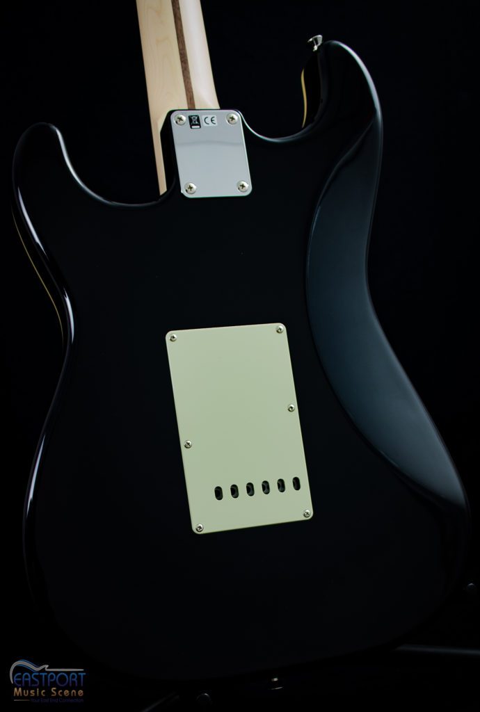 A black guitar with a white back plate.