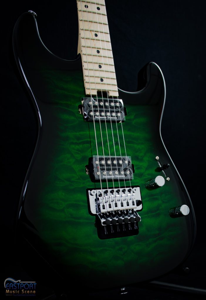 A green electric guitar with black body and white neck.
