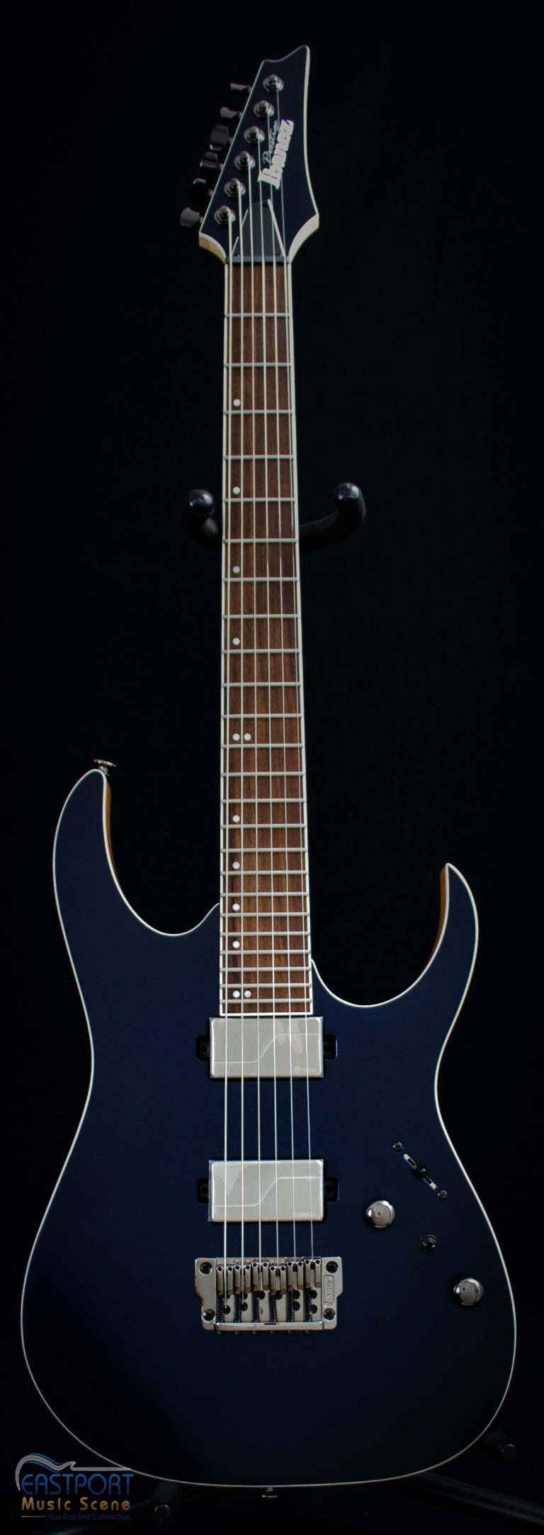 A blue electric guitar with six strings and a white neck.