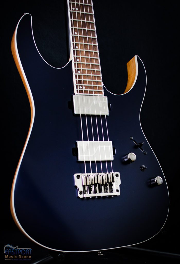 A black electric guitar with six strings and a white headstock.