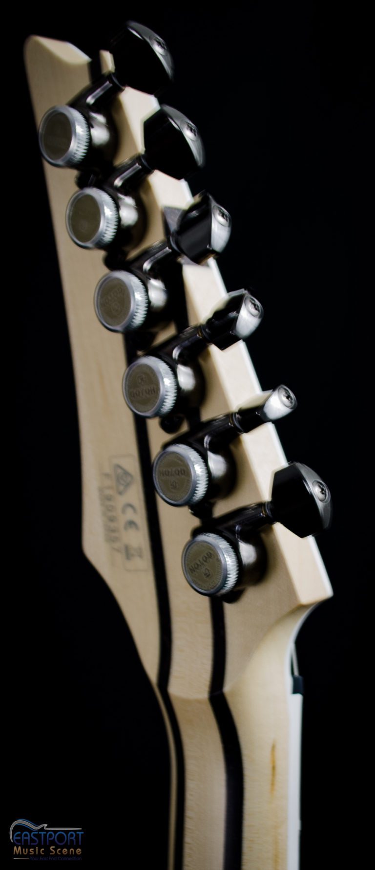 A guitar with six strings and three different types of tuners.
