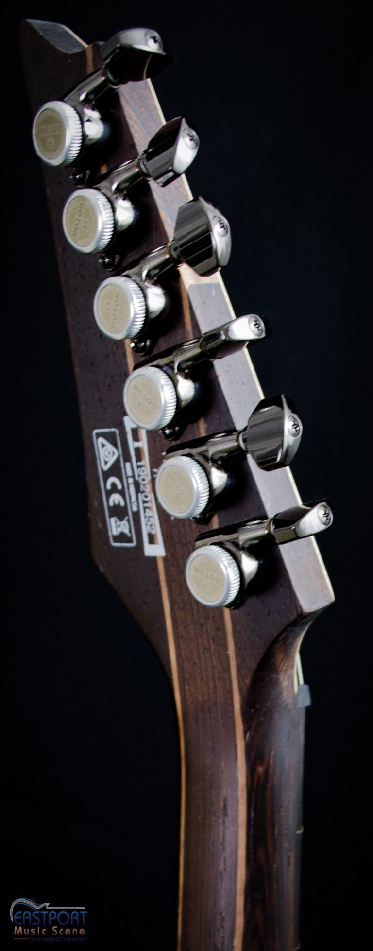 A close up of the headstock and four buttons.