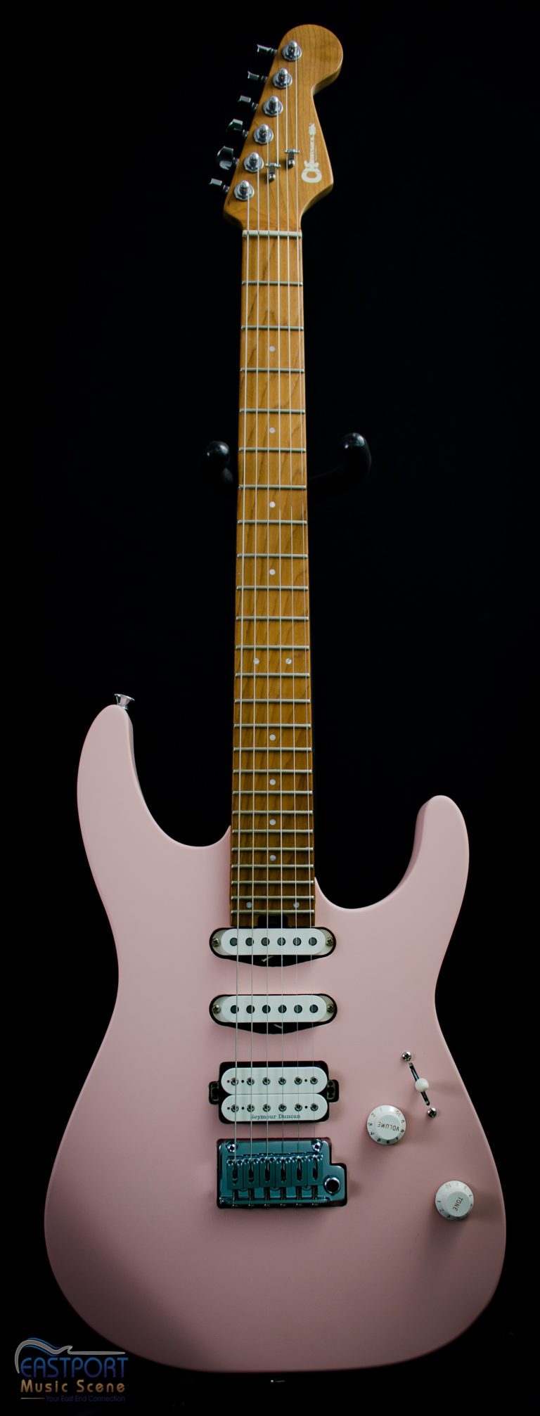 A pink electric guitar with the strings missing.