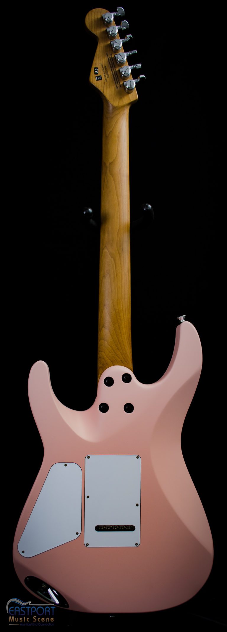 A pink guitar with black dots on the neck.