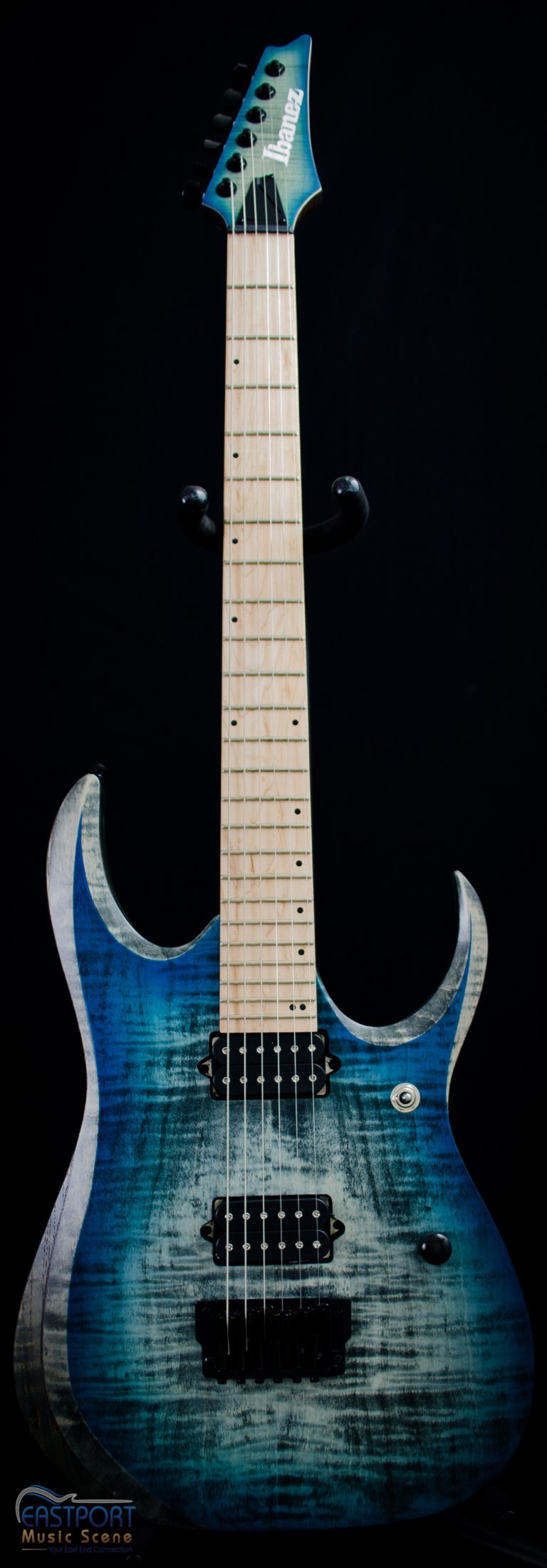 A blue electric guitar with white trim and black background