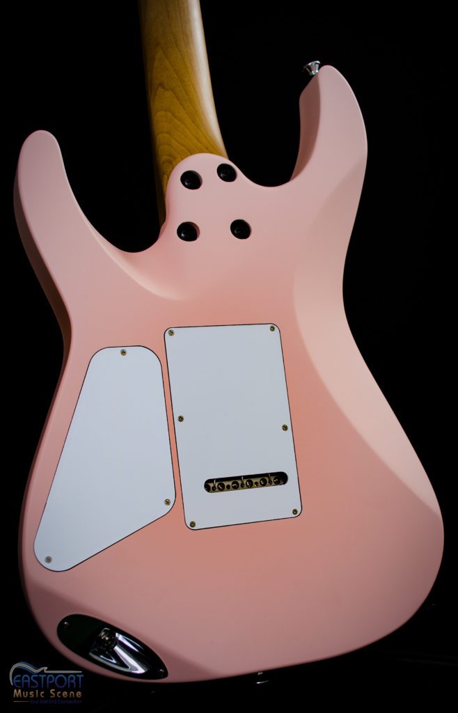 A pink guitar with two white and black knobs.