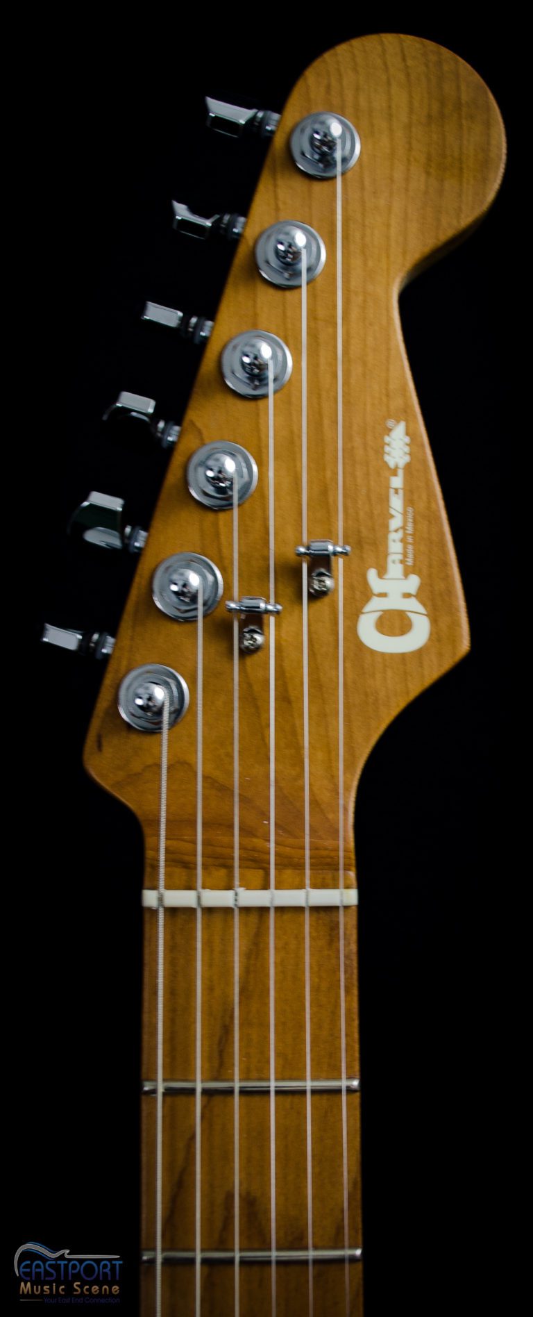 A close up of the neck and headstock on an electric guitar.