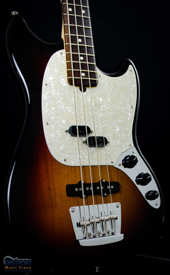 A close up of the front end of an electric bass guitar.