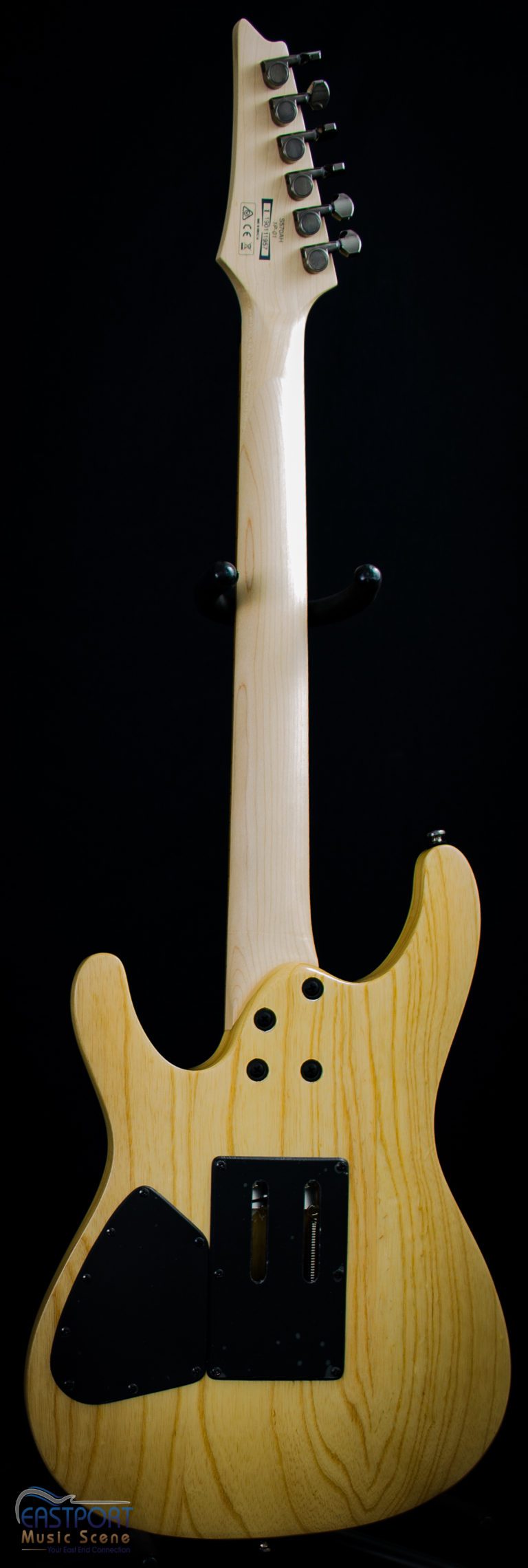 A guitar with a wooden body and a white face.