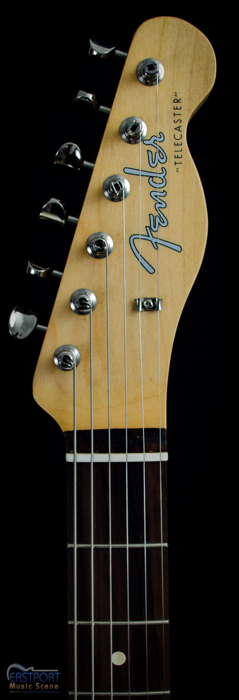 A close up of the neck and headstock of an electric guitar.
