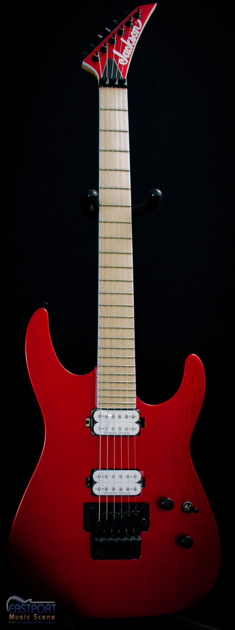 A red electric guitar with white strings and black back.