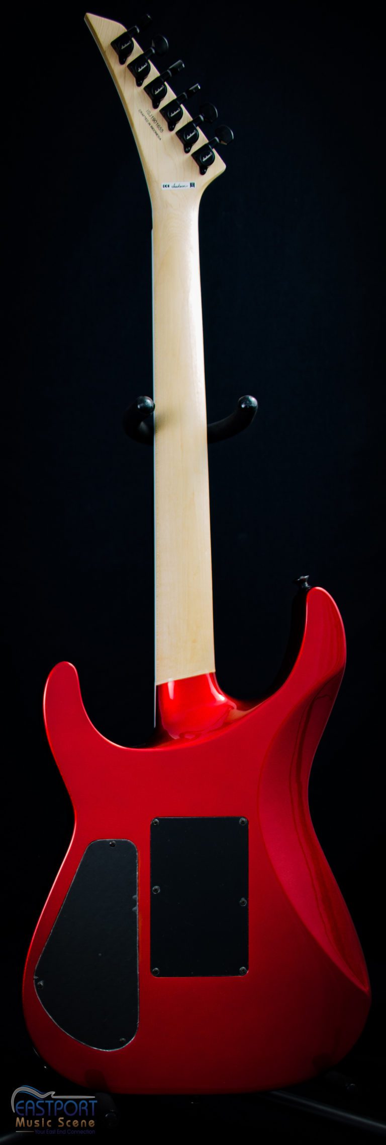 A red guitar with a white handle and black head.