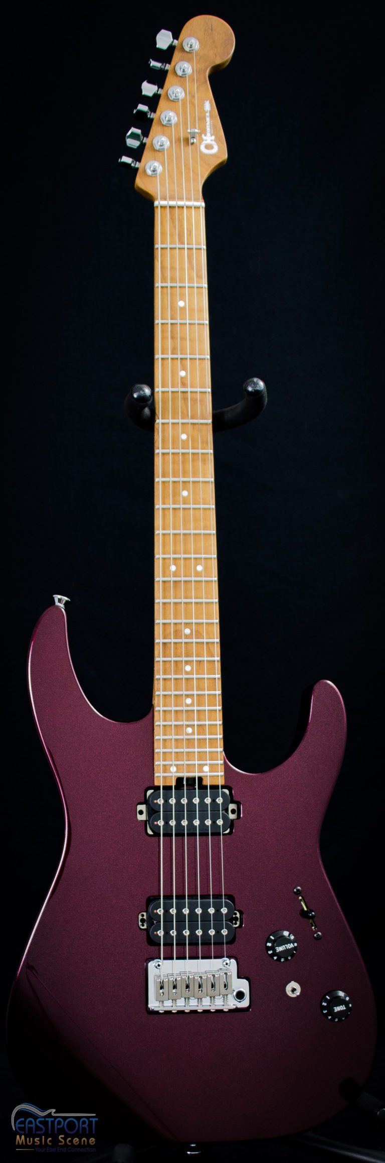 A purple guitar with white dots on the neck