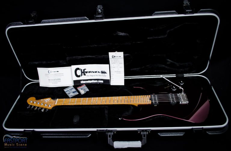 A guitar in its case with the strings and wires laid out.