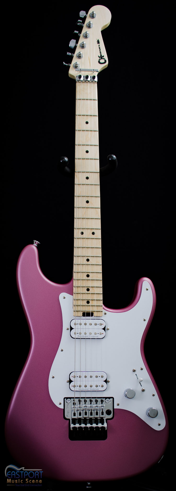 A pink electric guitar with white neck and body.