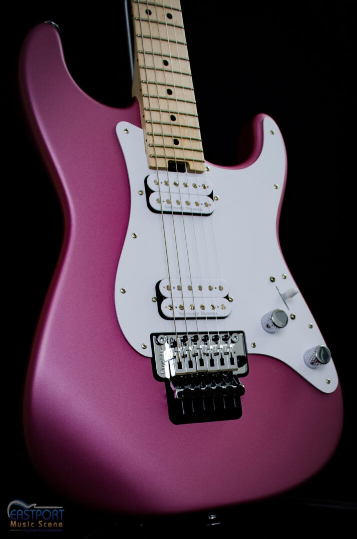 A pink electric guitar with white knobs and strings.