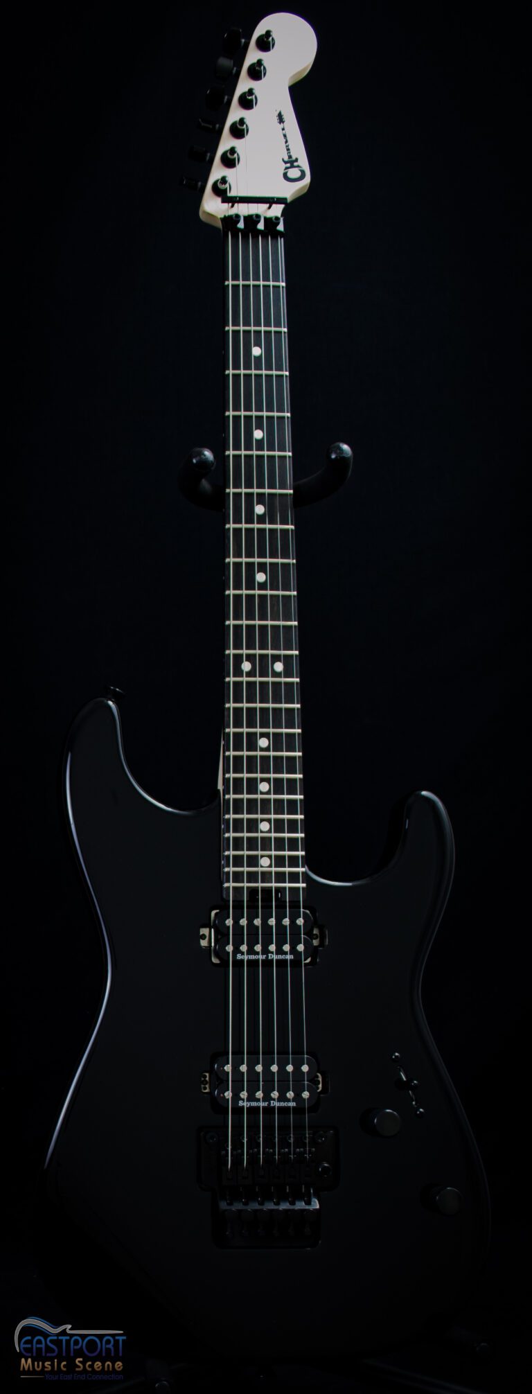A black electric guitar with the strings missing.