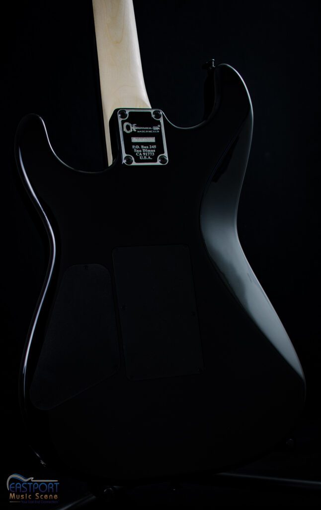 A black electric guitar with the back of it.