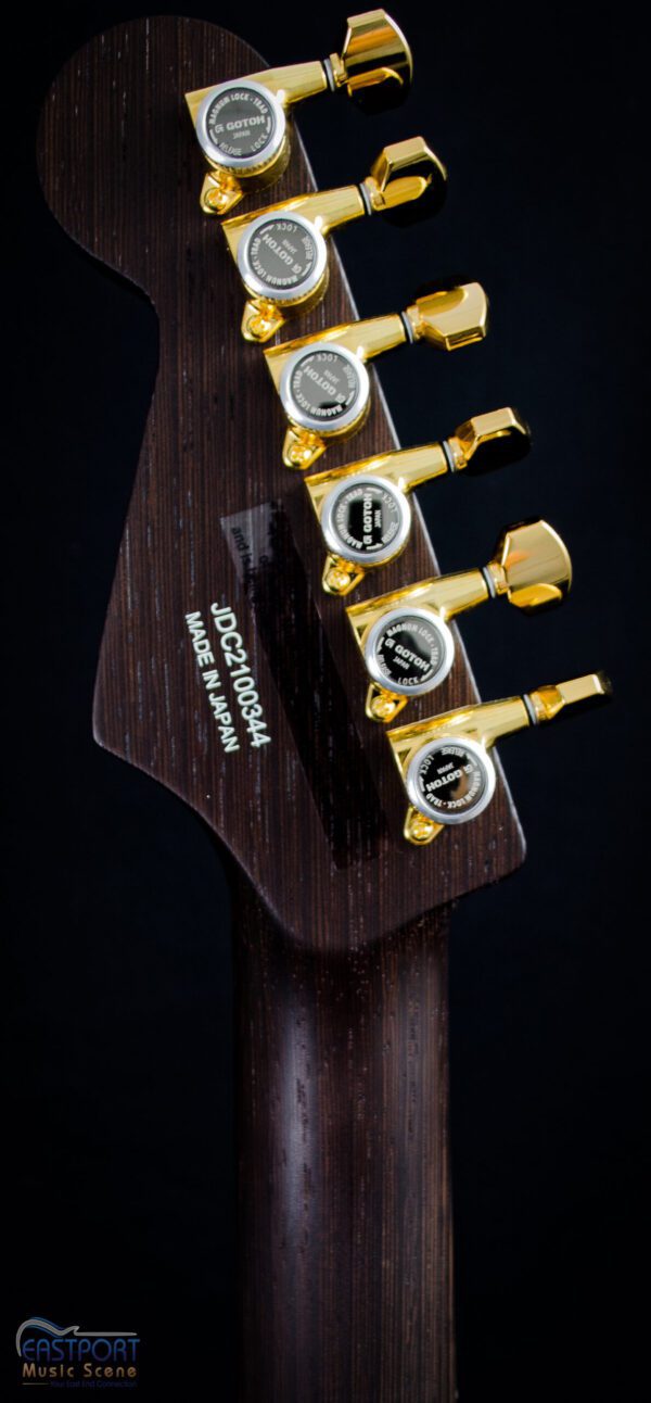 A guitar with four gold plated tuners.