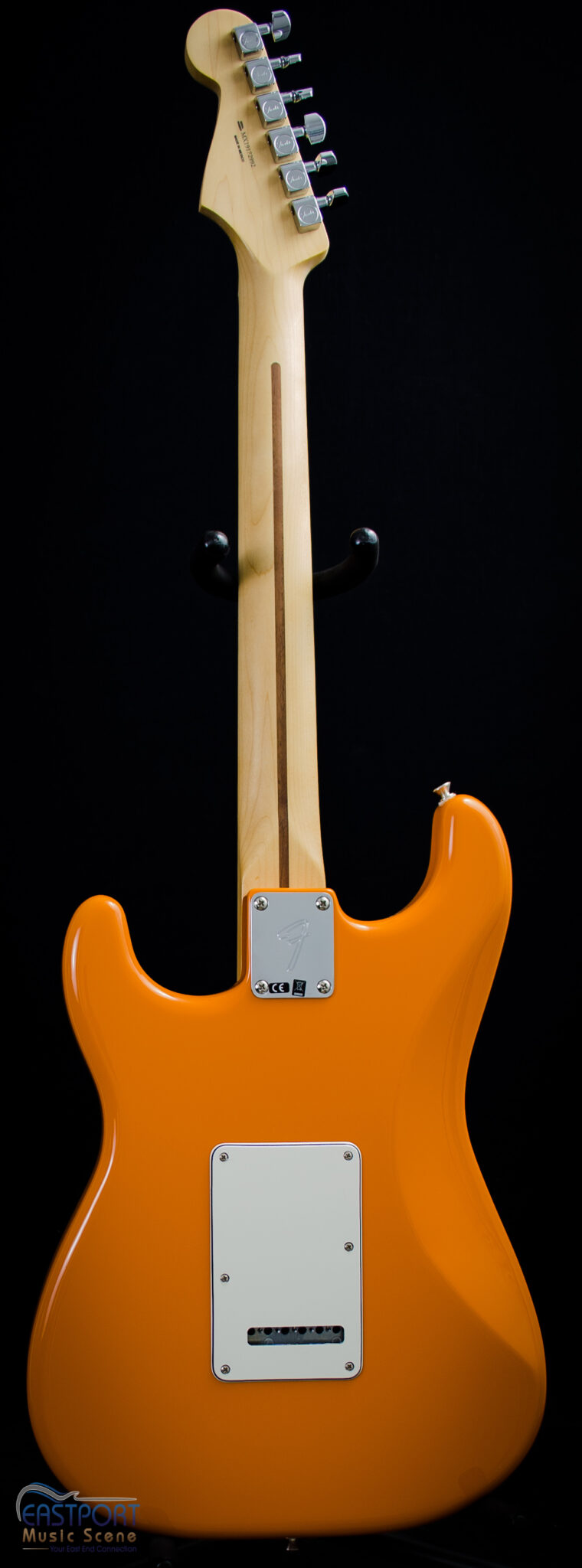 A close up of the back end of an orange electric guitar.