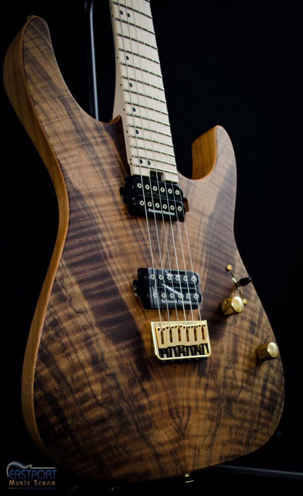 A close up of the neck and body of an electric guitar.