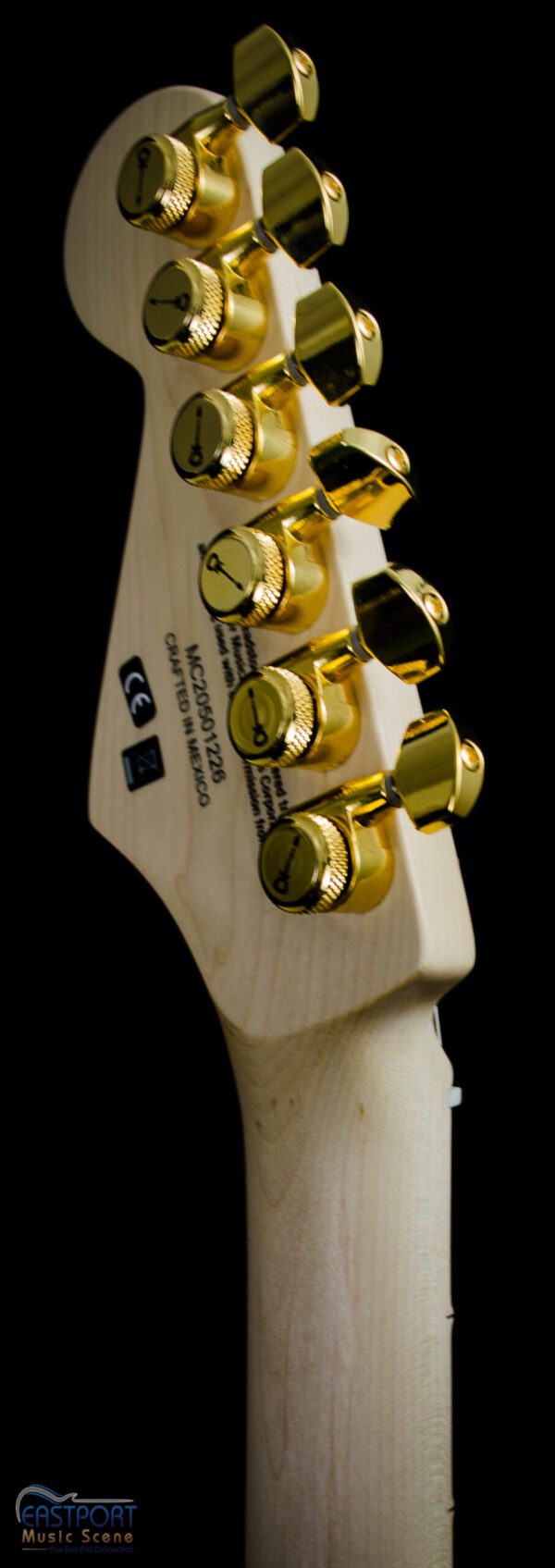 A close up of the headstock and buttons on an electric guitar.