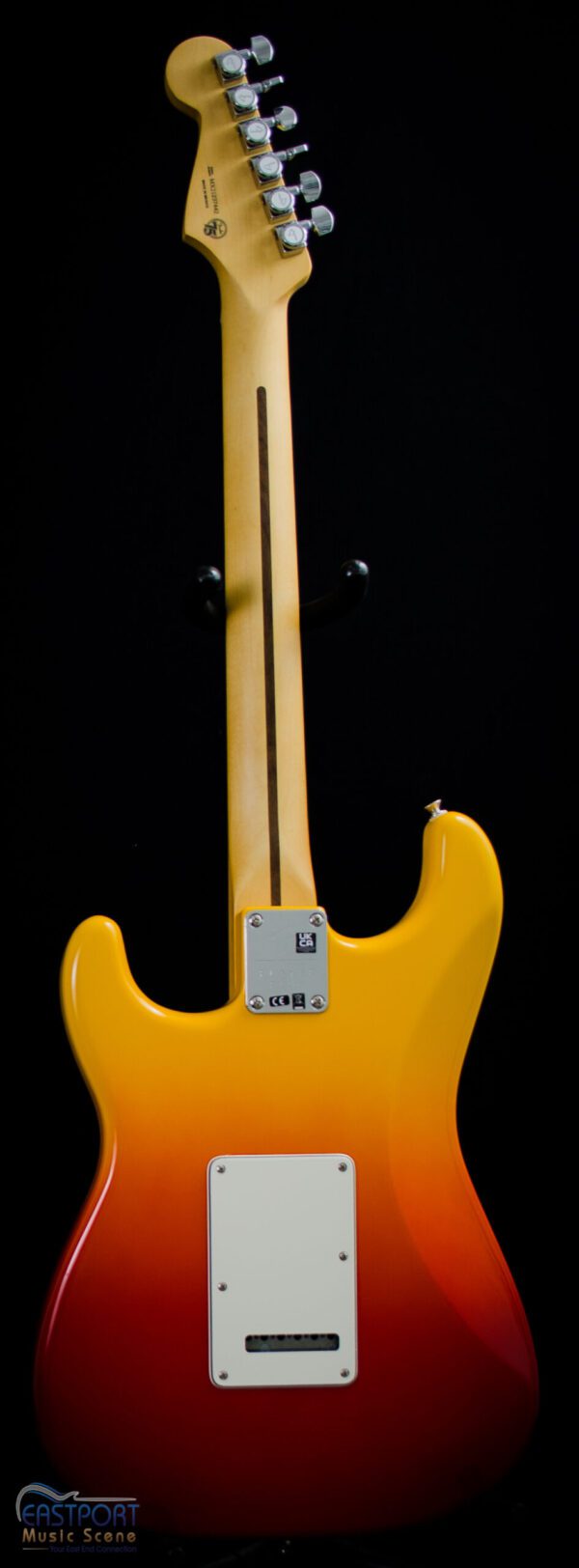 A yellow electric guitar with a black background