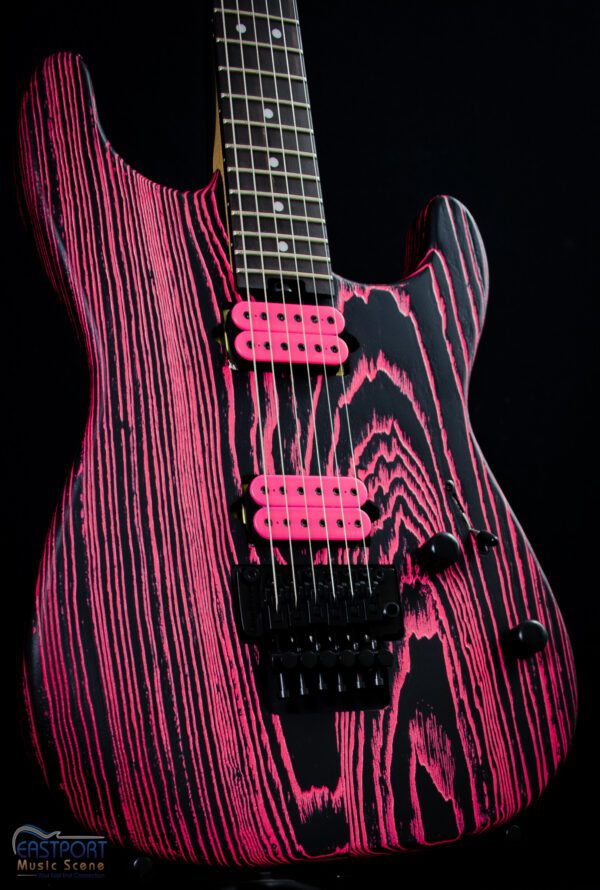 A pink electric guitar with black wood grain.